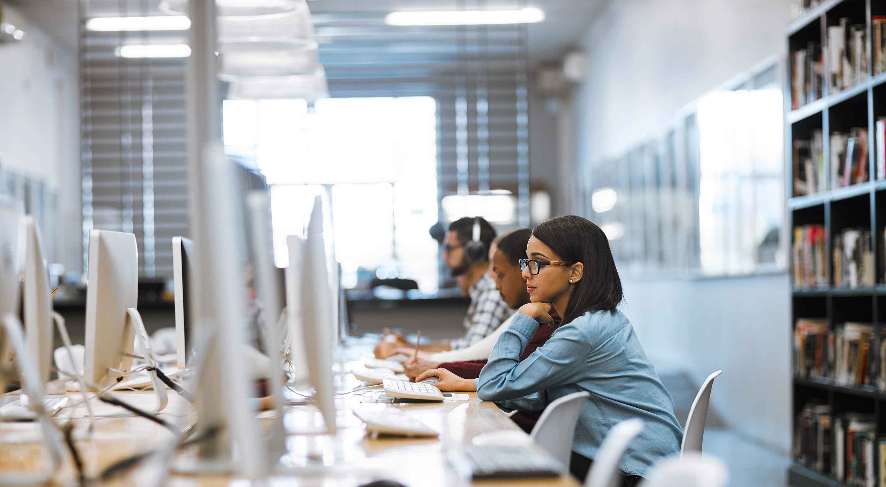 Shot of a group of university students working on computers in the library at campus